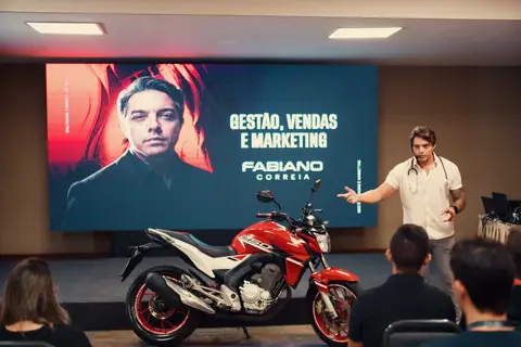 Palco do evento com a moto e o painel do Fabiano Correia